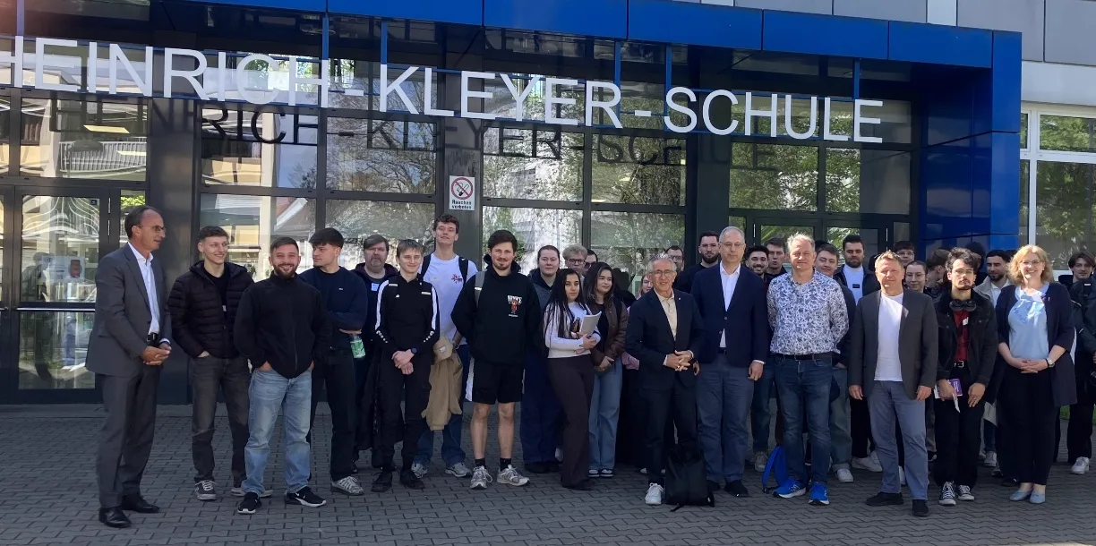 Gruppenbild aller Teilnehmenden vor dem Haupteingang der Heinrich-Kleyer-Schule